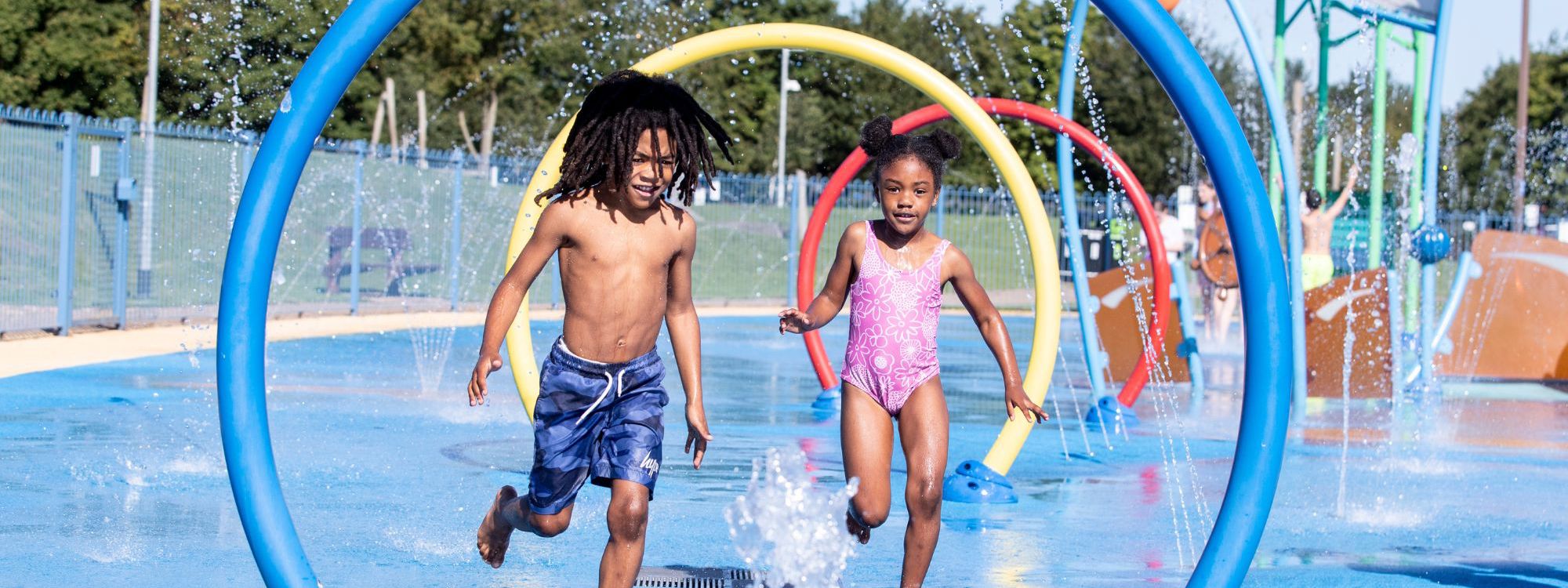 Two children running through water feature at Splash n Play in Milton Keynes