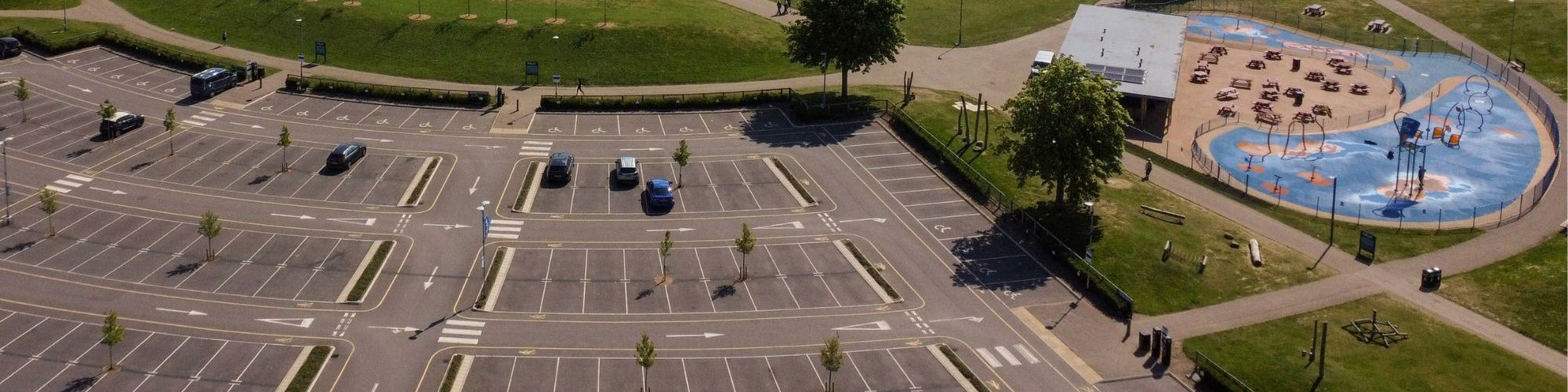 Birds eye view of car park, observation wheel and the lake