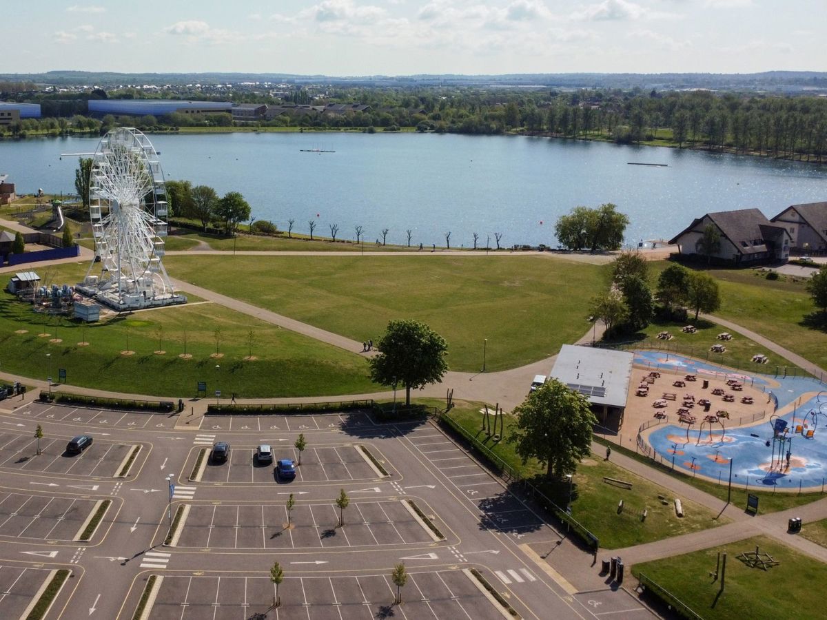 Birds eye view of car park, observation wheel and the lake