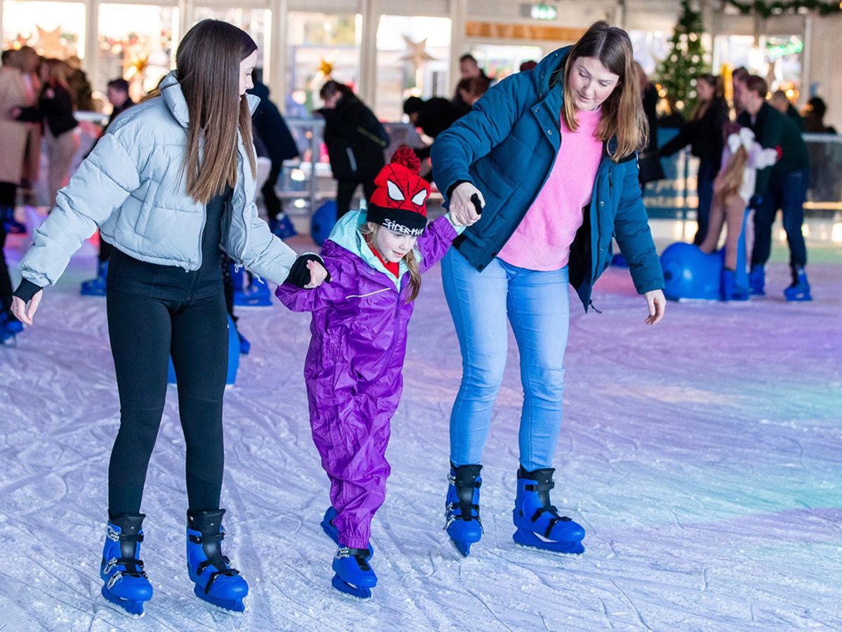 People helping each other to ice skate at Willen Lake