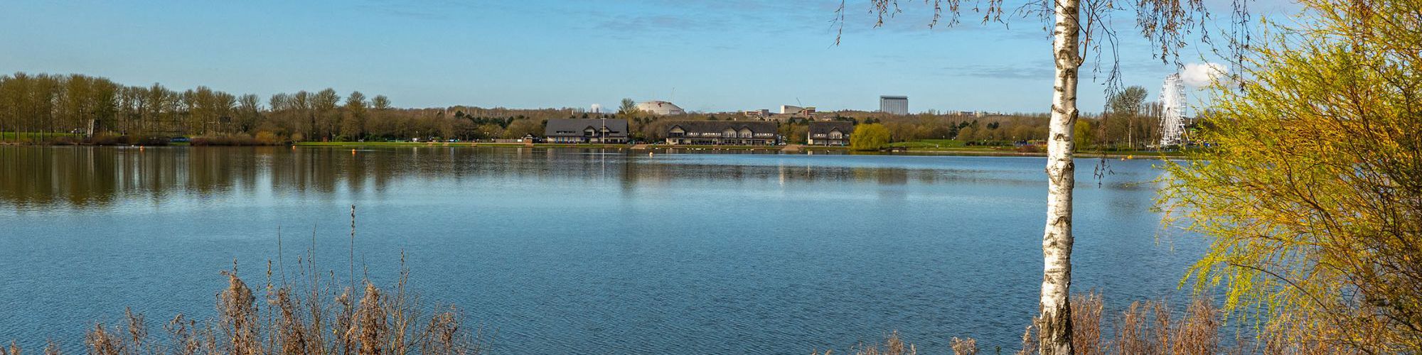 View across Willen Lake with Xscape building and Hotel La Tour in the distance