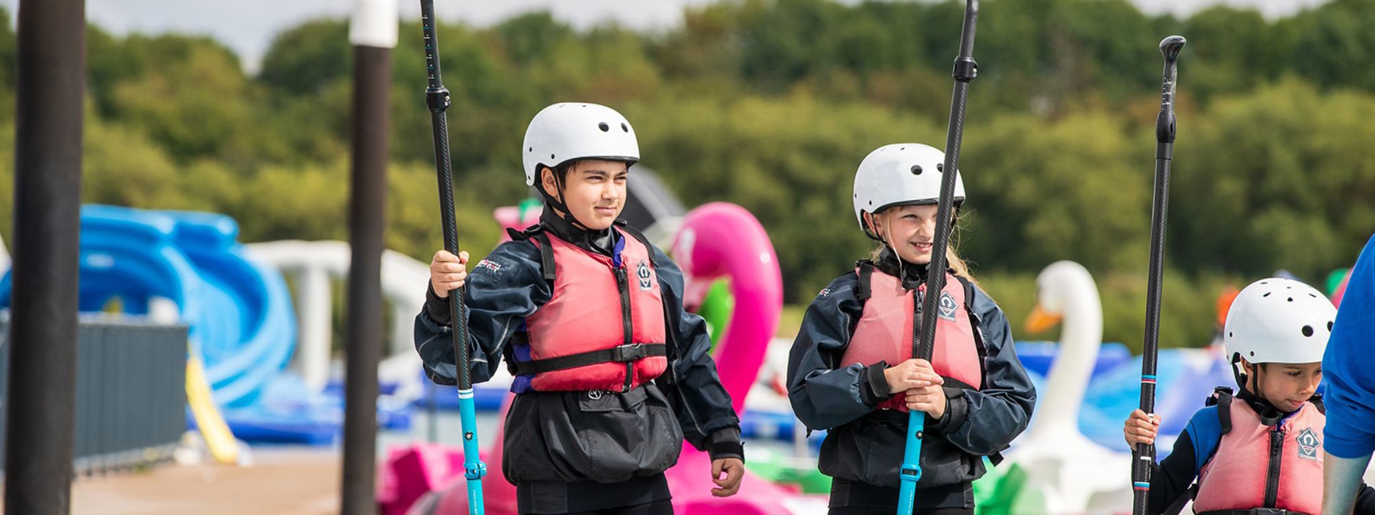 Children holding paddles for watersports session