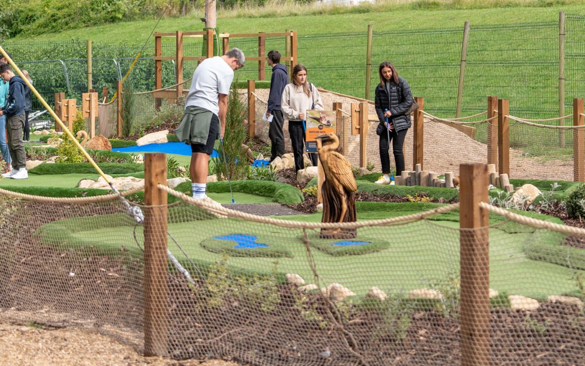 People playing Adventure Golf at Willen Lake with wildlife sculptures