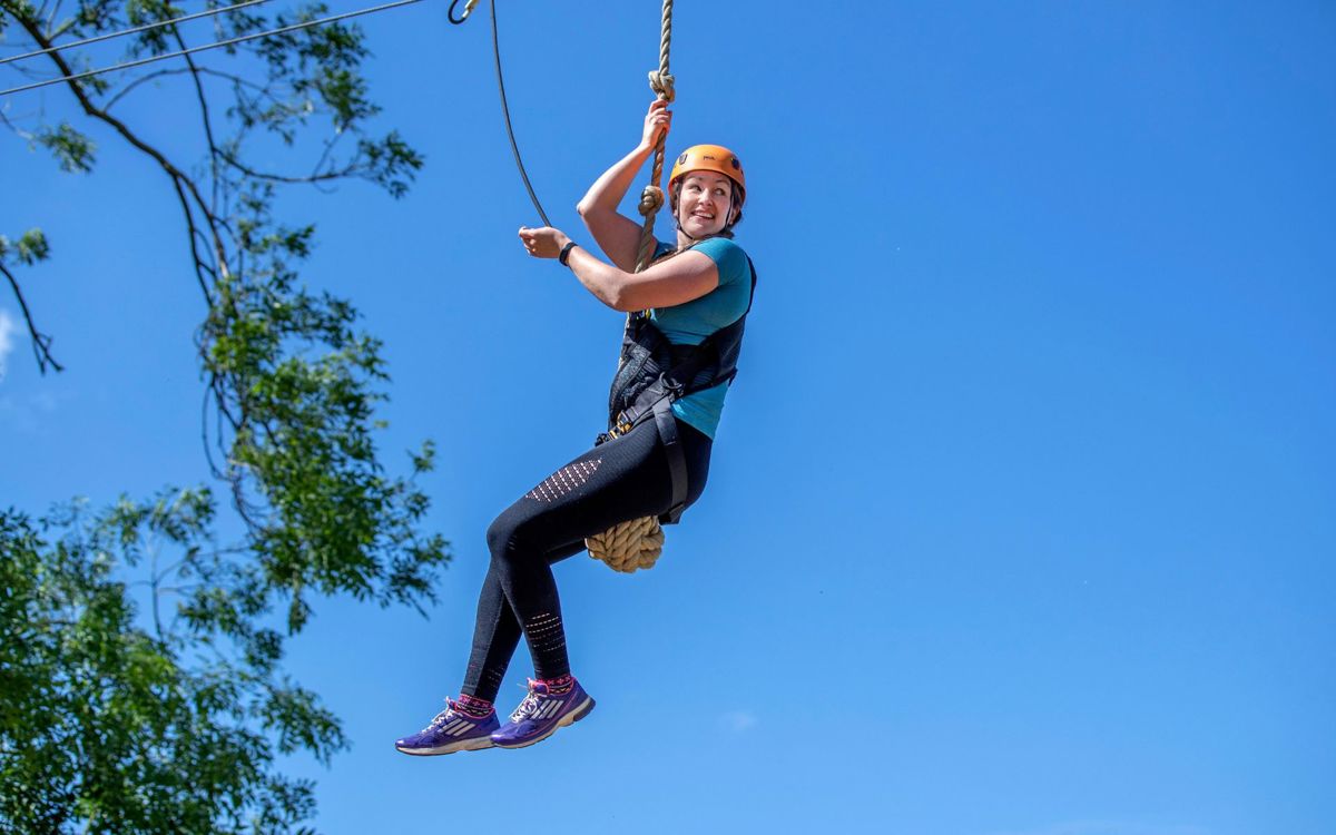 Adult on zip wire on Treetop Extreme high ropes course at Willen Lake