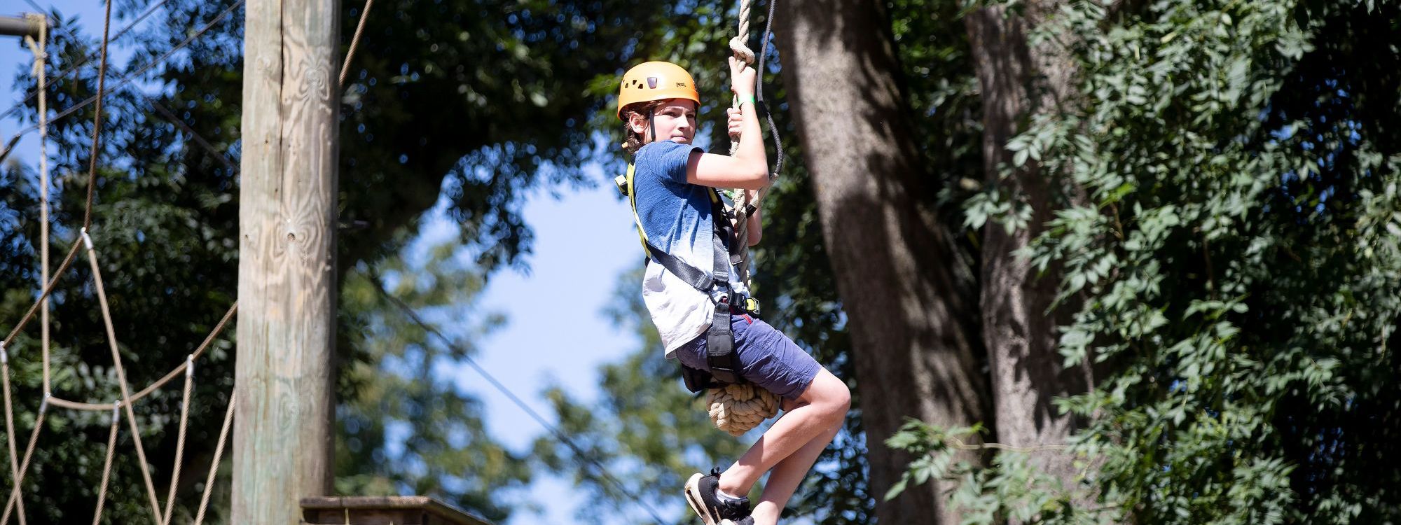 Child on zip wire on Treetop Adventure high ropes course at Willen Lake