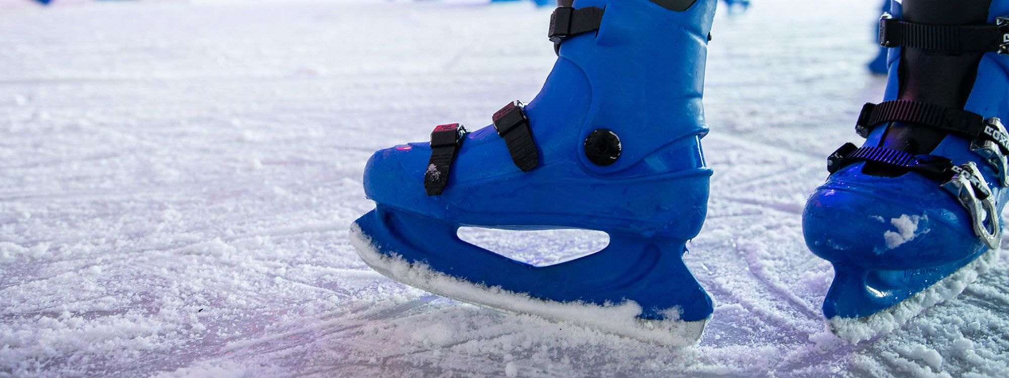 Blue ice skates on skating rink