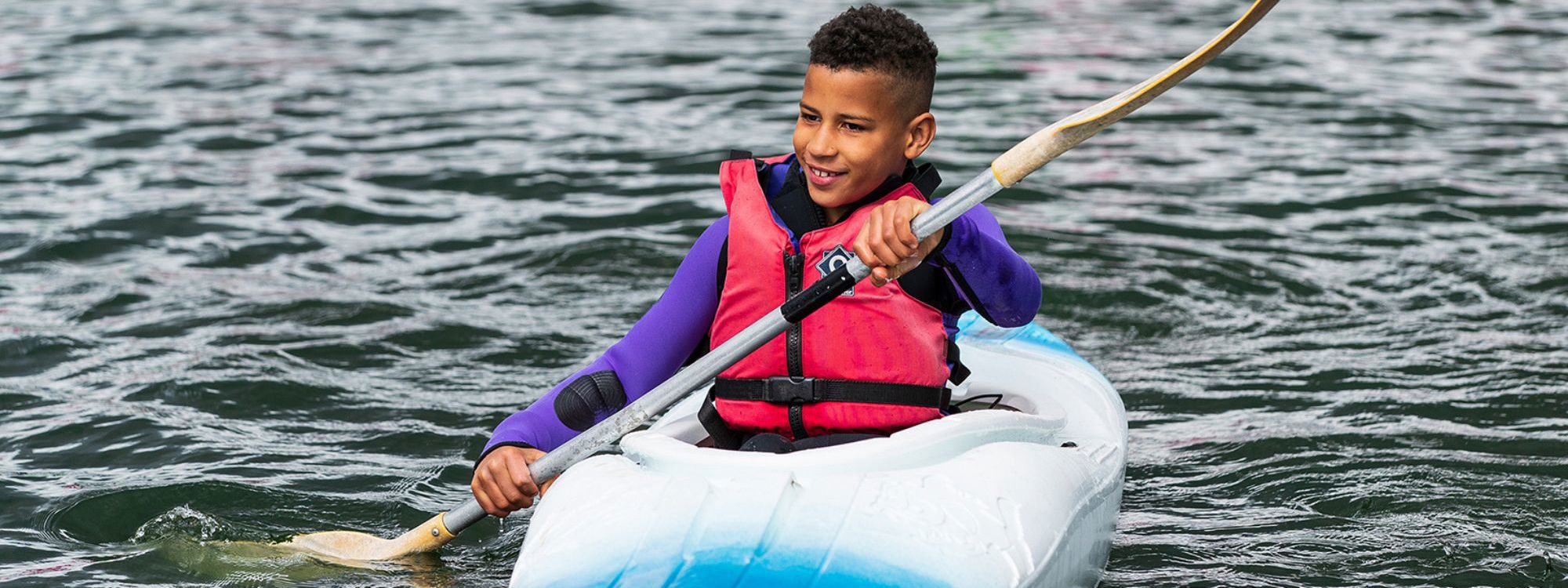 Person kayaking with paddle on Willen Lake in Milton Keynes