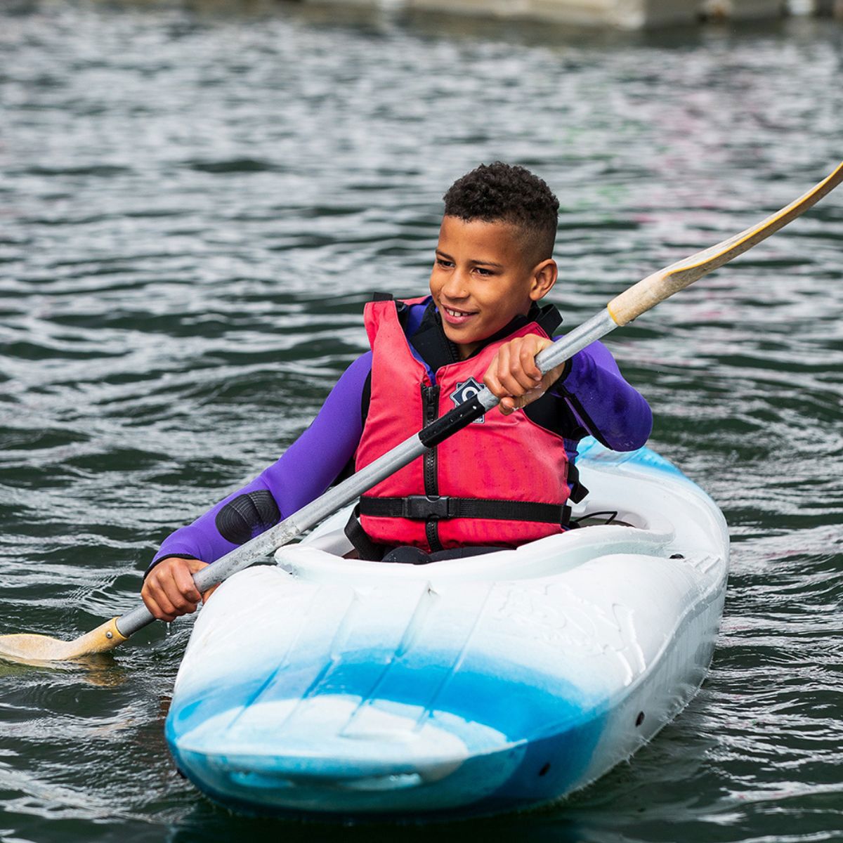 Person kayaking with paddle on Willen Lake in Milton Keynes