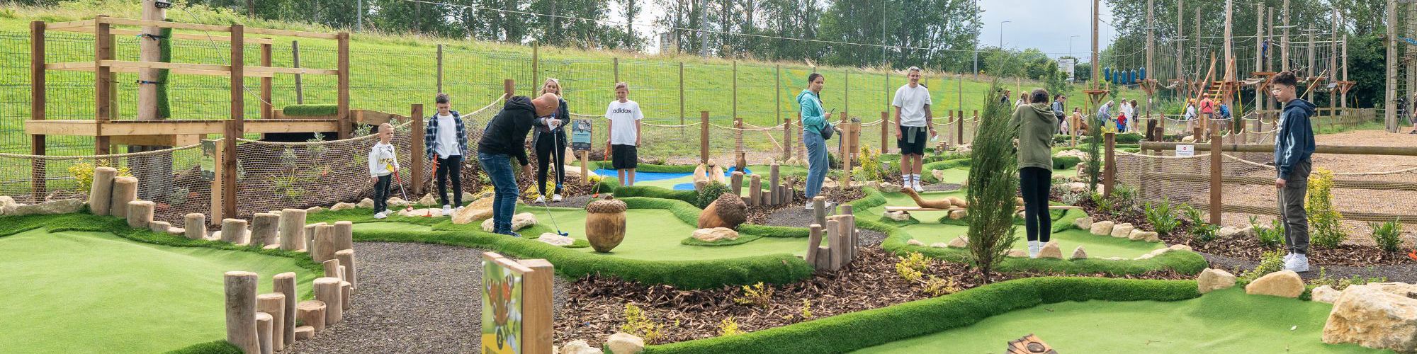 Families playing adventure golf